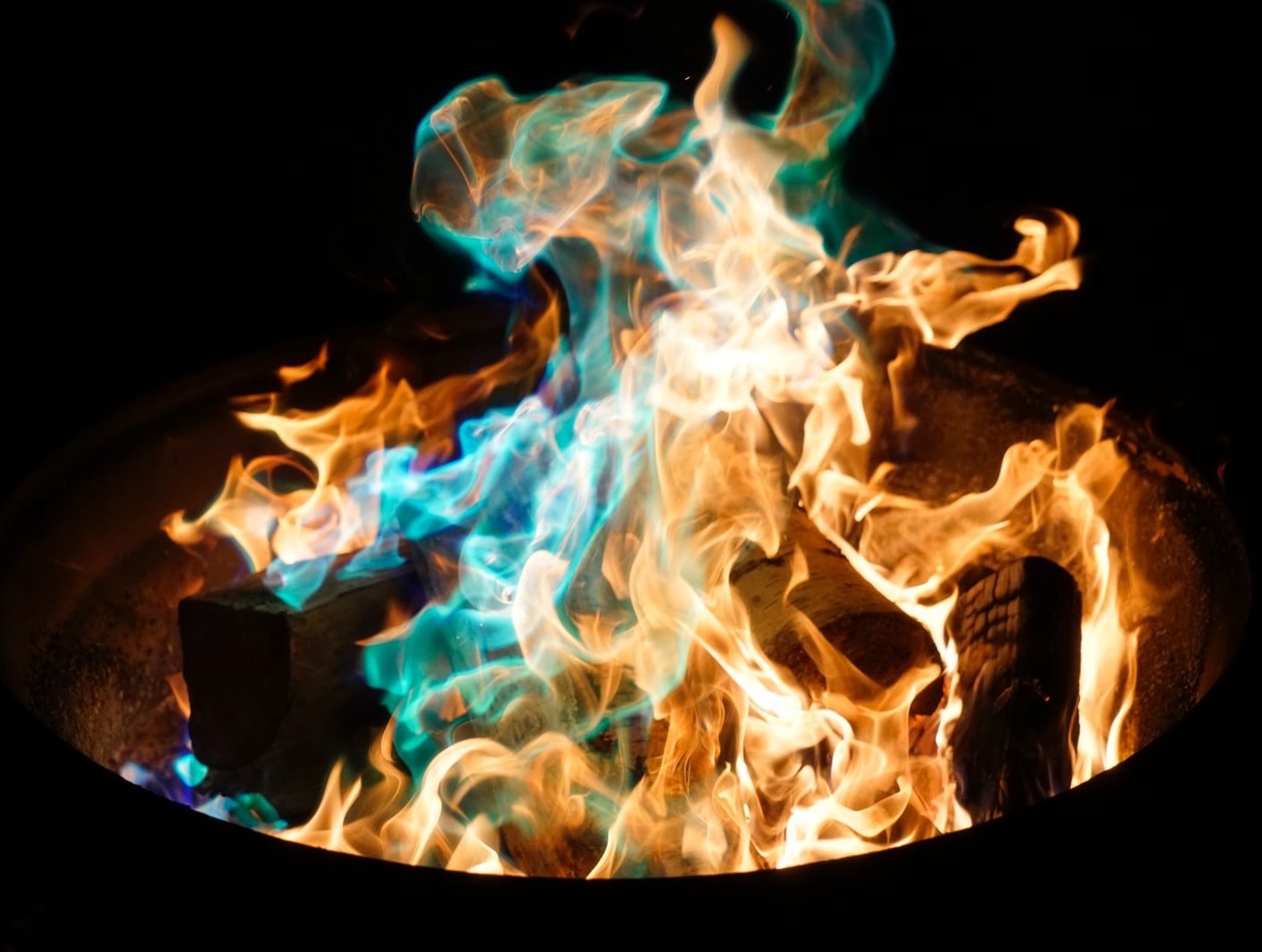 orange and blue flame on pile of wood